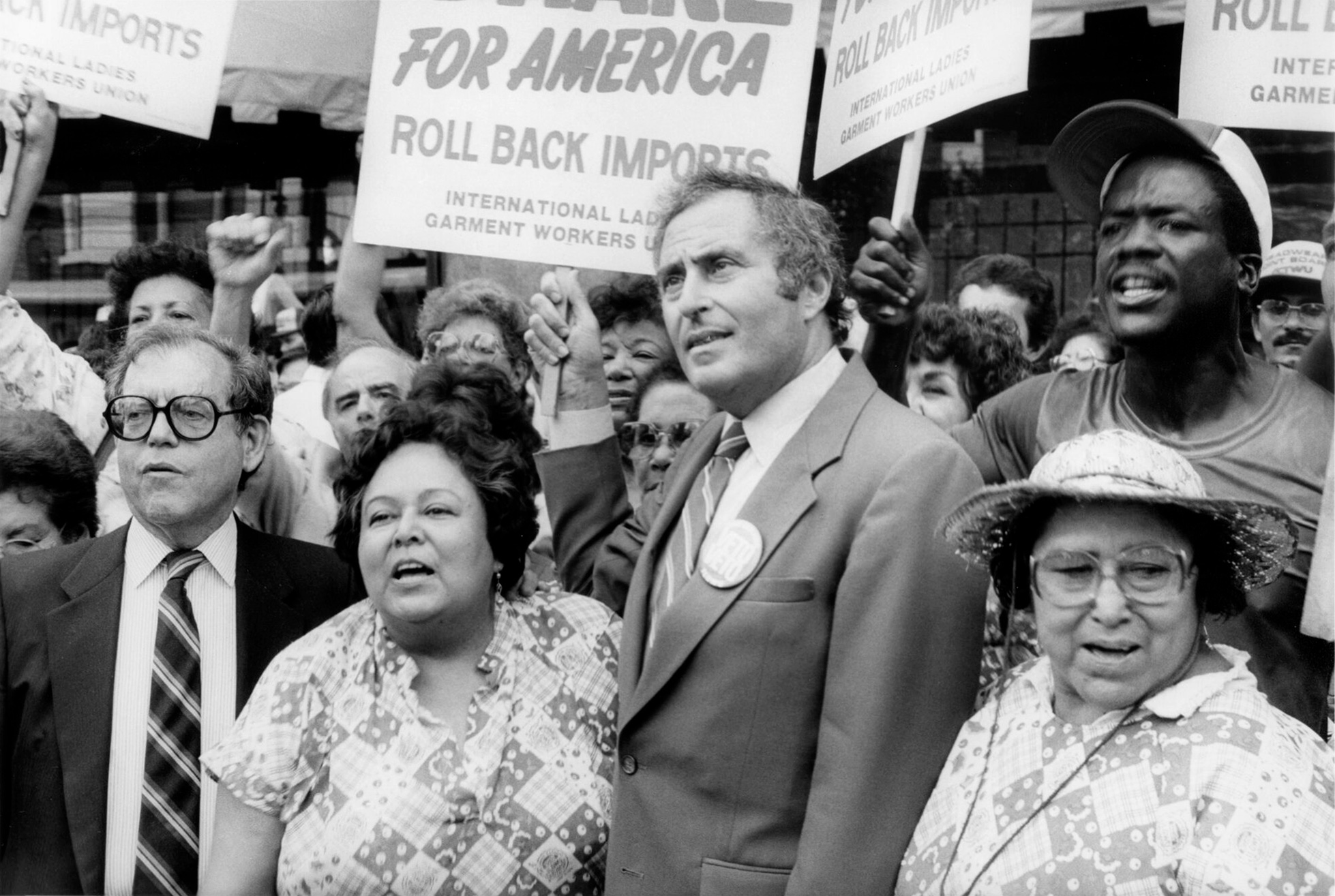Kathy Andrade standing beside Jay Mazur at a rally, surrounded by union members holding protest signs.